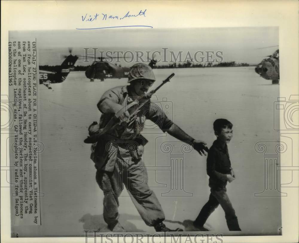 1965 Press Photo U.S. Marine shoos boy away from helicopters; Tam Loc, Vietnam