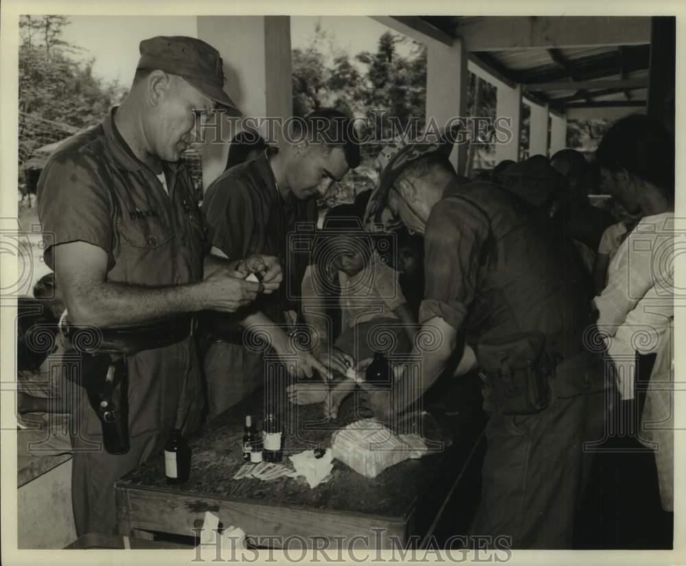 1969 Press Photo Navy men help child; Medical Asst. Mission at DaNang, Vietnam