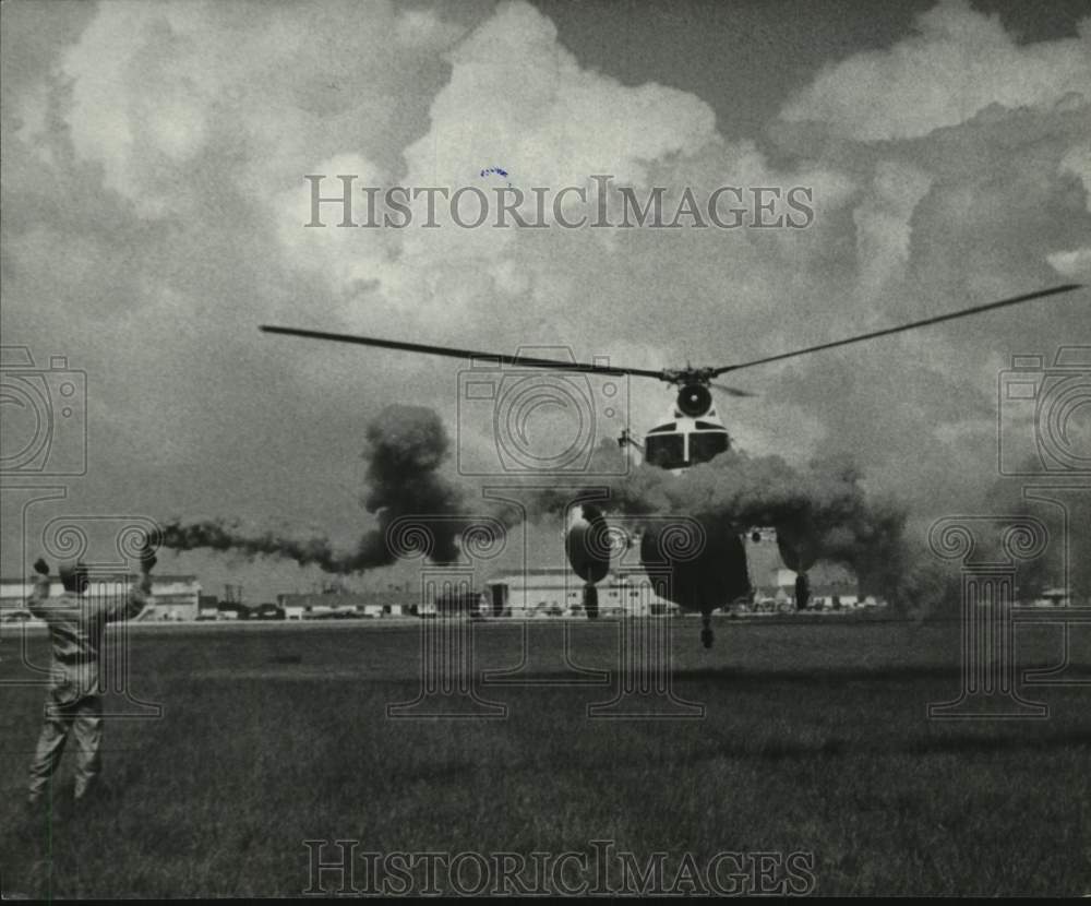 1964 Press Photo Soldier uses red smoke to direct copter landing - Ellington AFB
