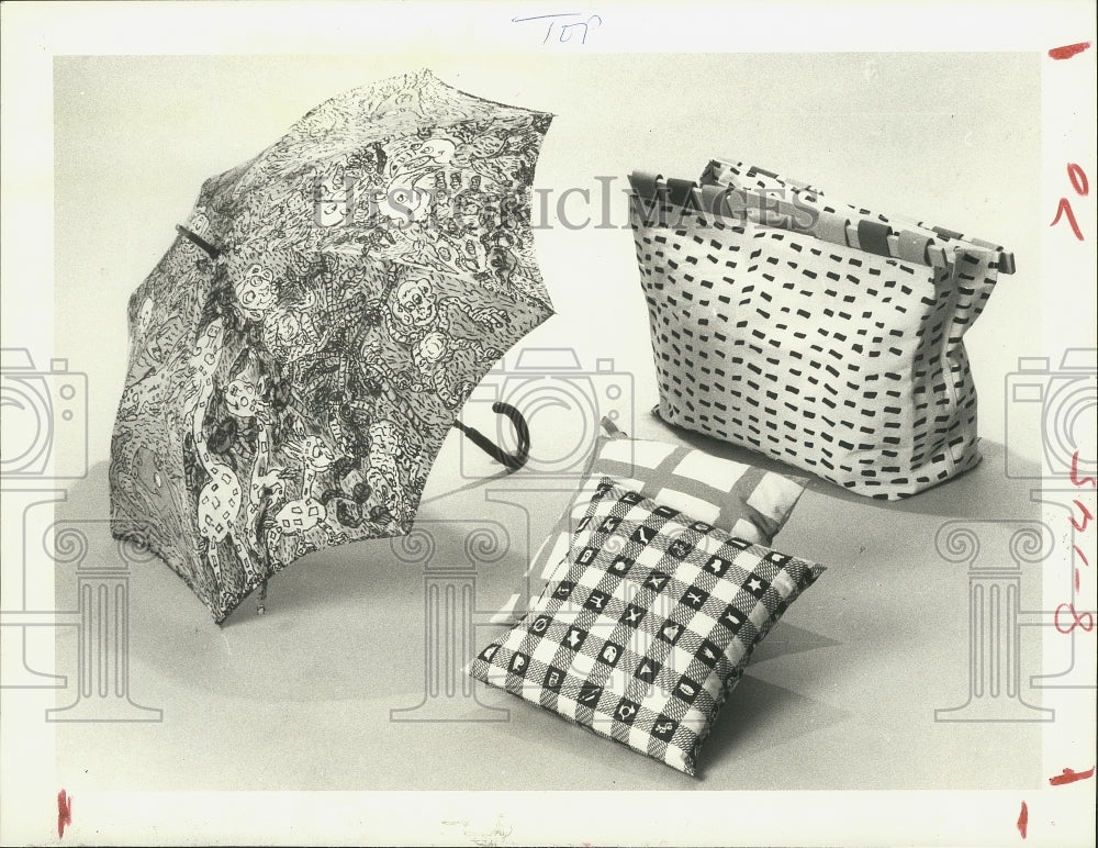 1986 Press Photo Artist designed fabrics on umbrella, bag, and pillow at museum