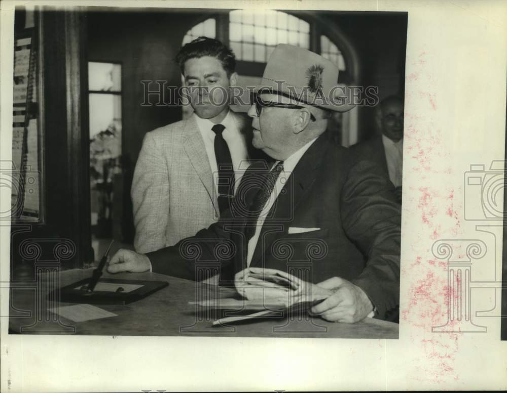 1957 Press Photo Two men speaking at a counter - hcp30454