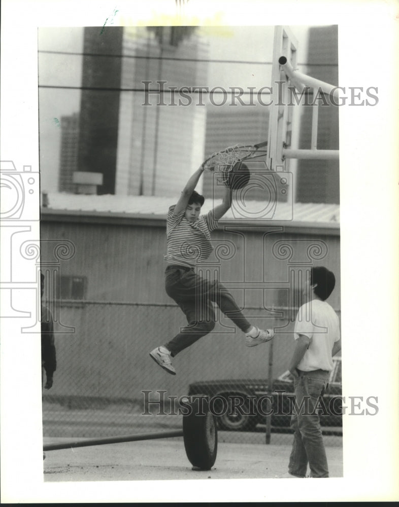 1989 Press Photo Sergio Torres dunks a basketball as friend looks on; in Houston- Historic Images