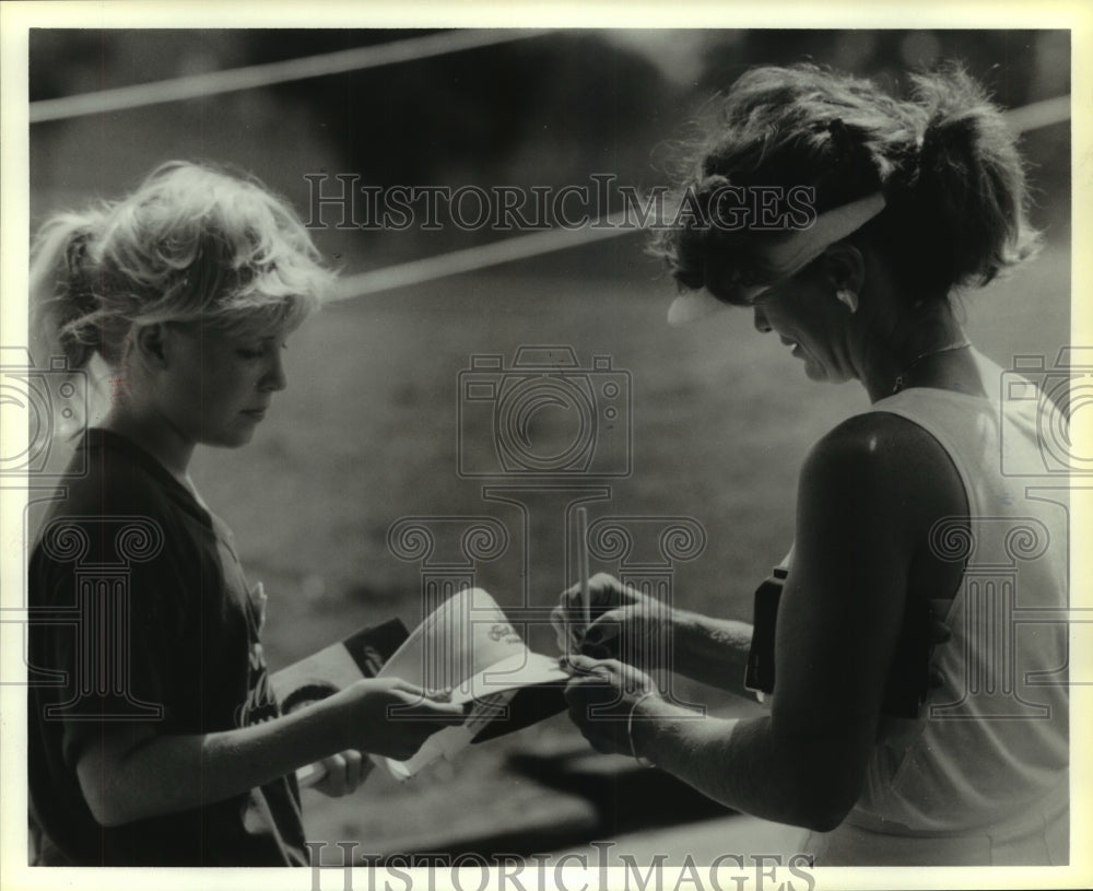 1986 Press Photo Pro golfer Judy Dickenson autographs cap for a young fan- Historic Images