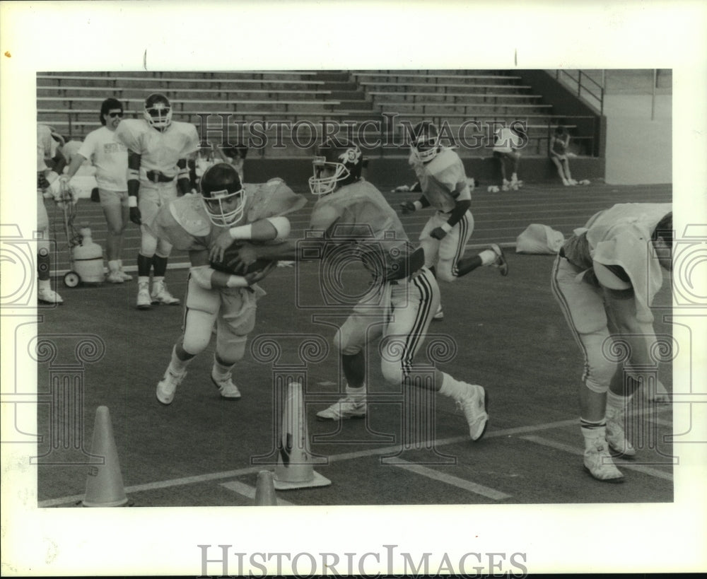 1988 Press Photo North Texas University&#39;s Davis hands ball to Moon at practice.- Historic Images