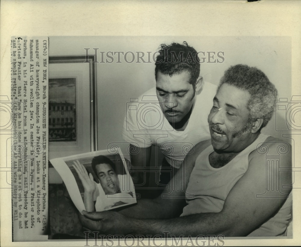 1971 Press Photo Joe Frazier manager, Yancy Durham and aide look at photo of Ali- Historic Images