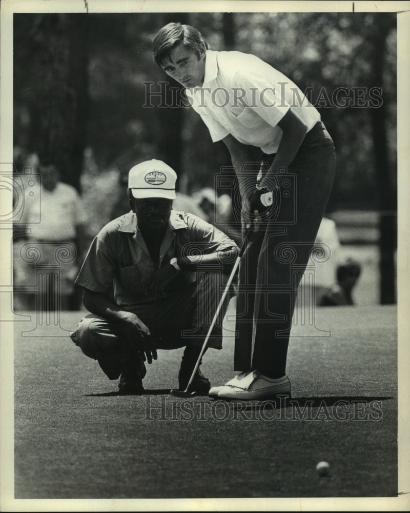 1971 Press Photo Pro golfer Dave Hill and his caddy watch putt on green.- Historic Images