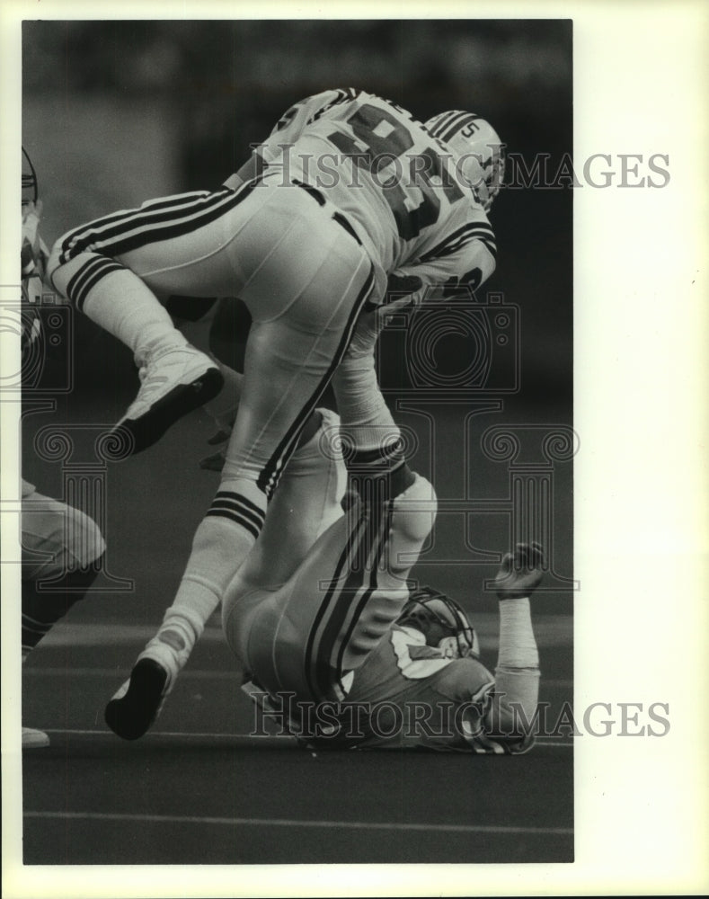 1988 Press Photo A Houston Oiler gives New England Patriot a leg up. - hcs05896- Historic Images