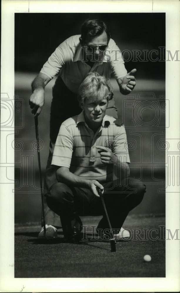 1987 Press Photo Bruce Devlin helps his son, Kel, line up a putt. - hcs06129- Historic Images