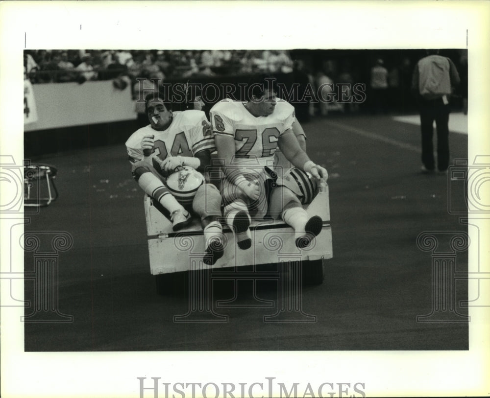 1987 Press Photo Injured Oilers Steve Brown, Vince Stroth are carted off field- Historic Images
