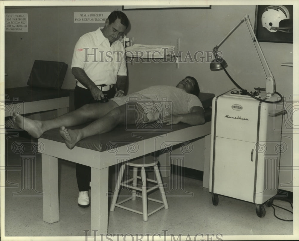 Press Photo Houston Oilers football player Bobby Gunn gets worked on by trainer.- Historic Images