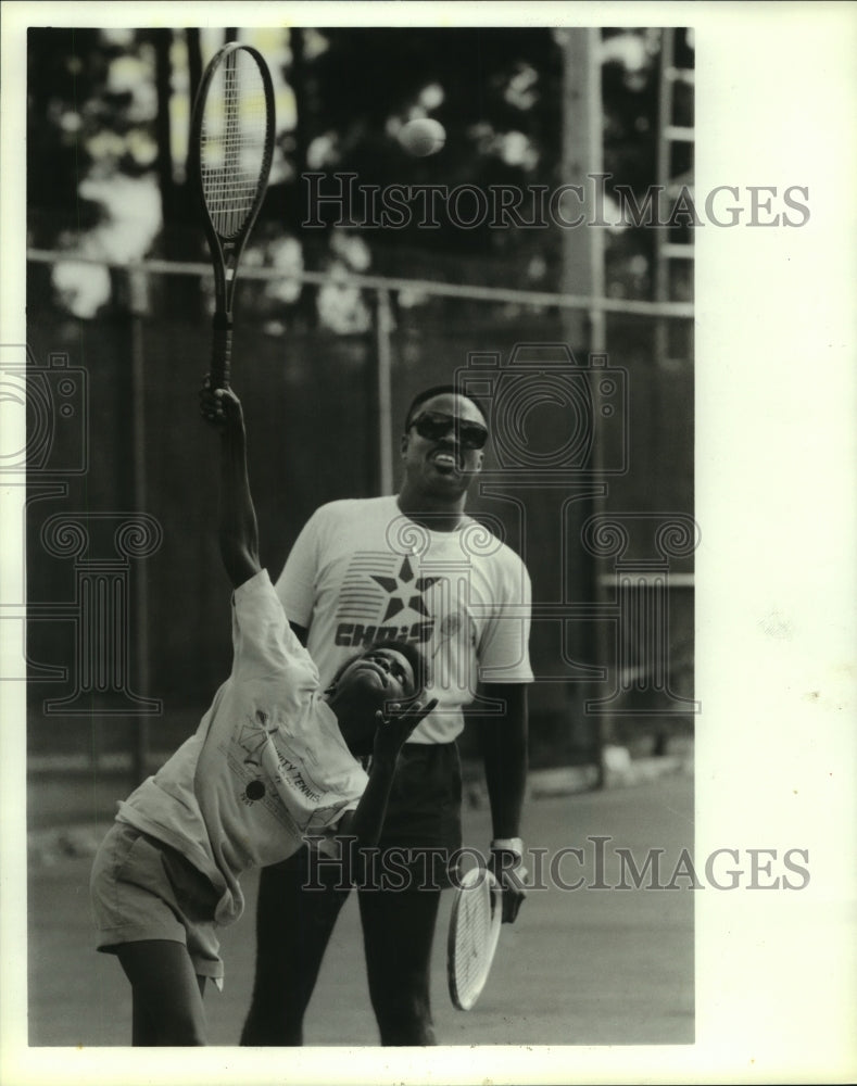 1988 Press Photo Tennis instructor Leonardo Johns helps 10-year-old Chiara Combs- Historic Images