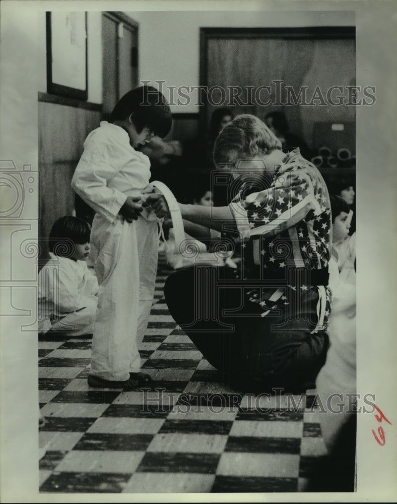 1978 Press Photo Karate black belt Tom Prichard helps student with their gi.- Historic Images