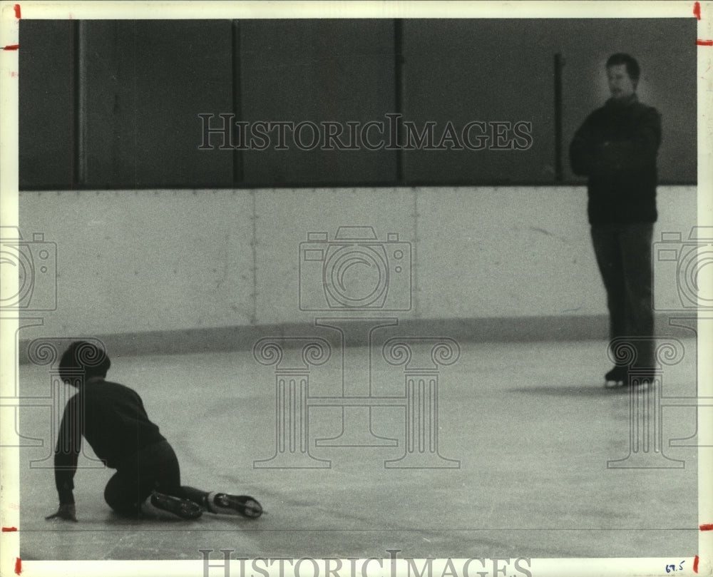 1985 Press Photo Skater Jennifer King falls after jump; coach Moyer looks on.- Historic Images