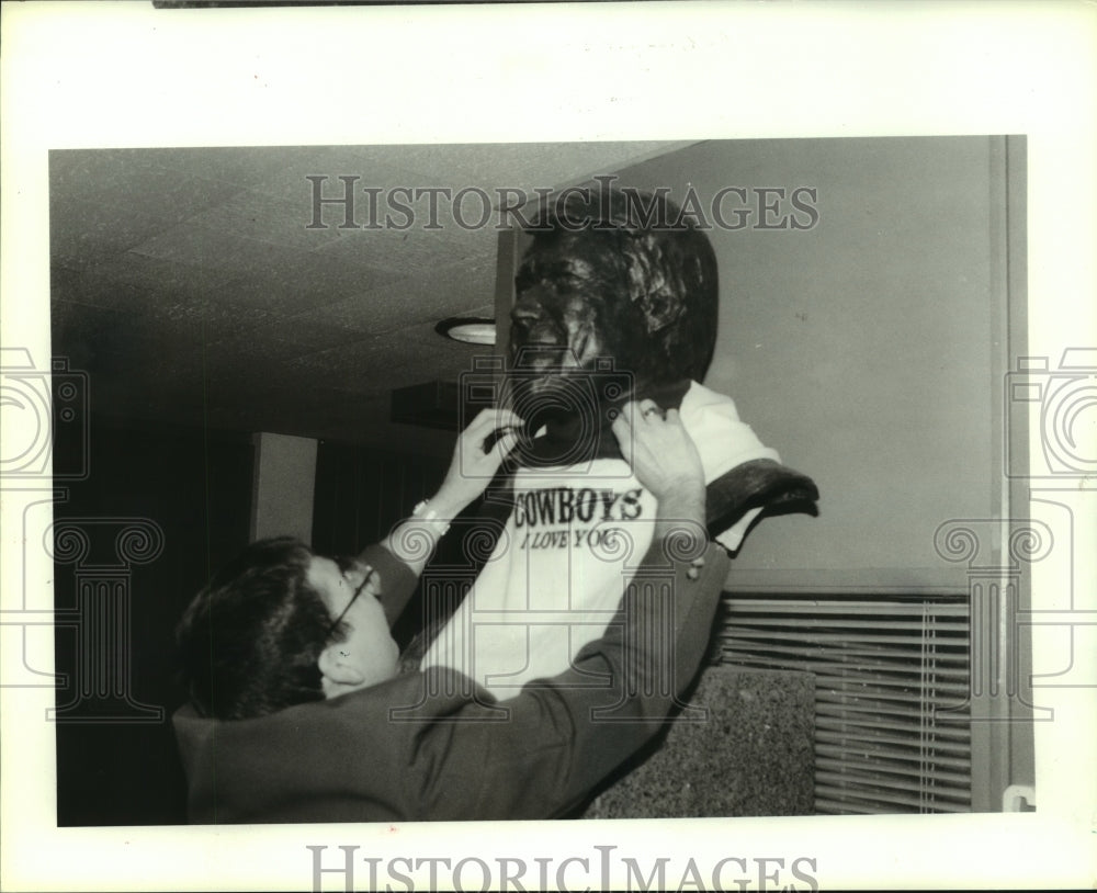 1989 Press Photo Fan puts t-shirt on bust of Dallas Cowboys coach Jimmy Johnson.- Historic Images