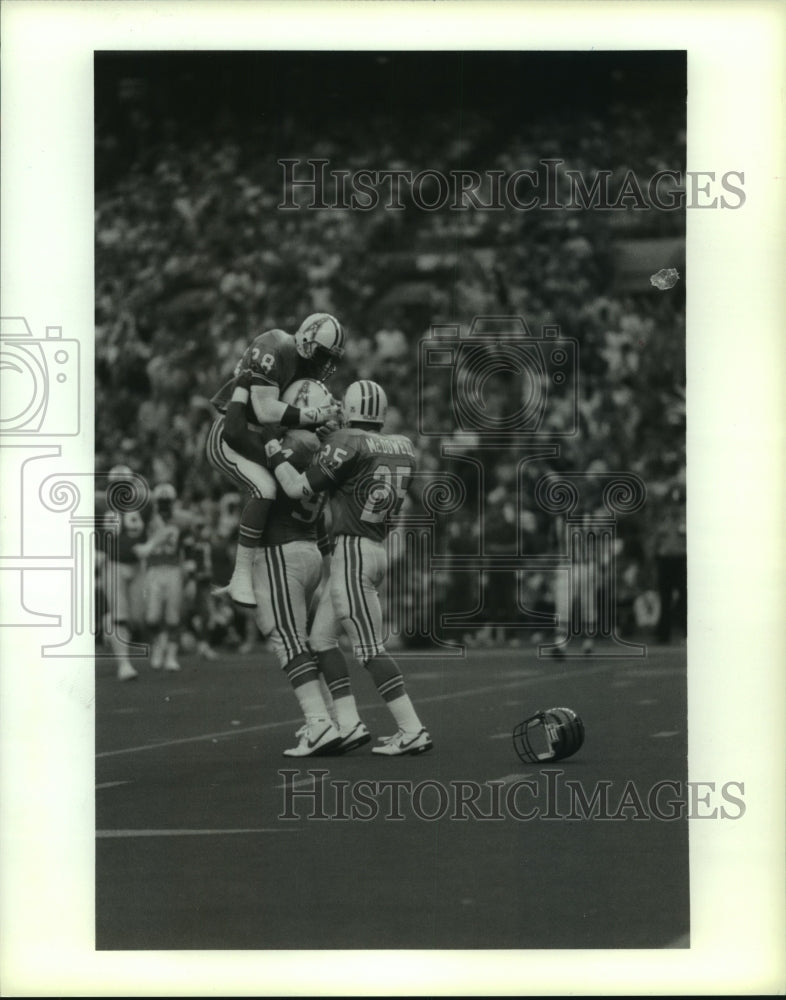1990 Press Photo Oilers defense celebrates hit that causes Bengal helmet loss.- Historic Images