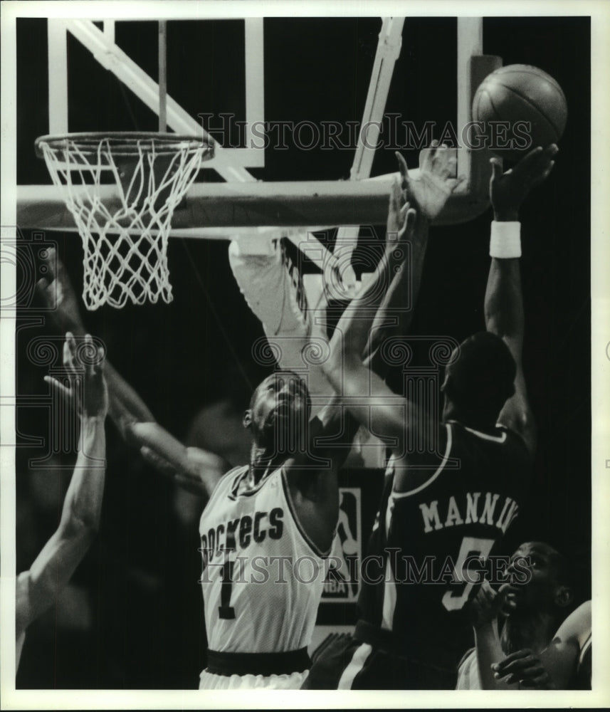 1990 Press Photo Rockets&#39; Buck Johnson leaps to block Manning&#39;s shot.- Historic Images