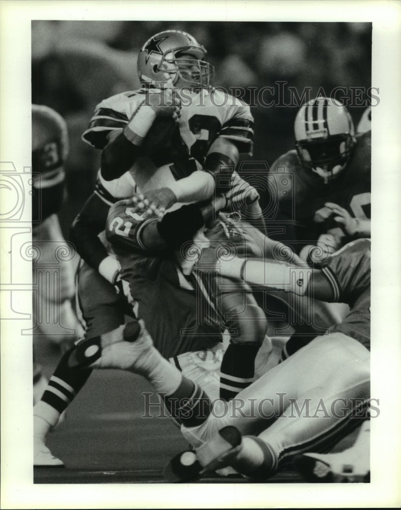 1991 Press Photo Cowboys&#39; Stan Sinagala is wrapped up for loss by Bo Orlando.- Historic Images