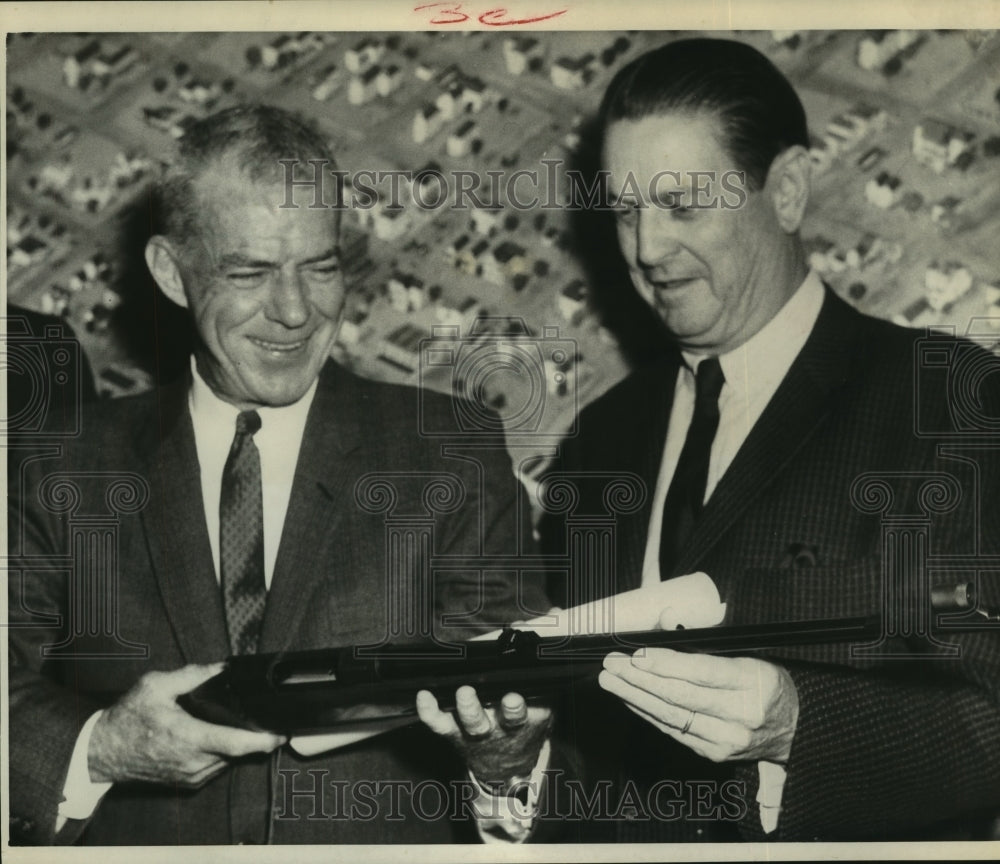 1964 Press Photo Johnny Keane and Claude Barrett examine rifle at luncheon.- Historic Images