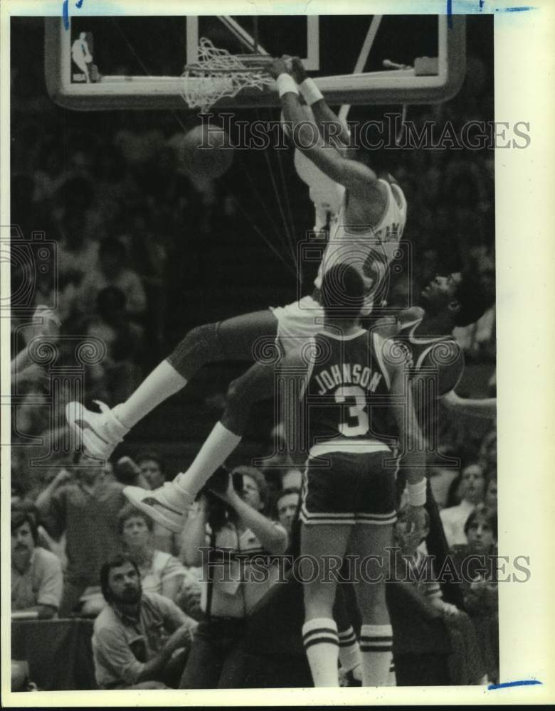 1986 Press Photo Rockets&#39; center Ralph Sampson hangs on rim after slam dunk.- Historic Images