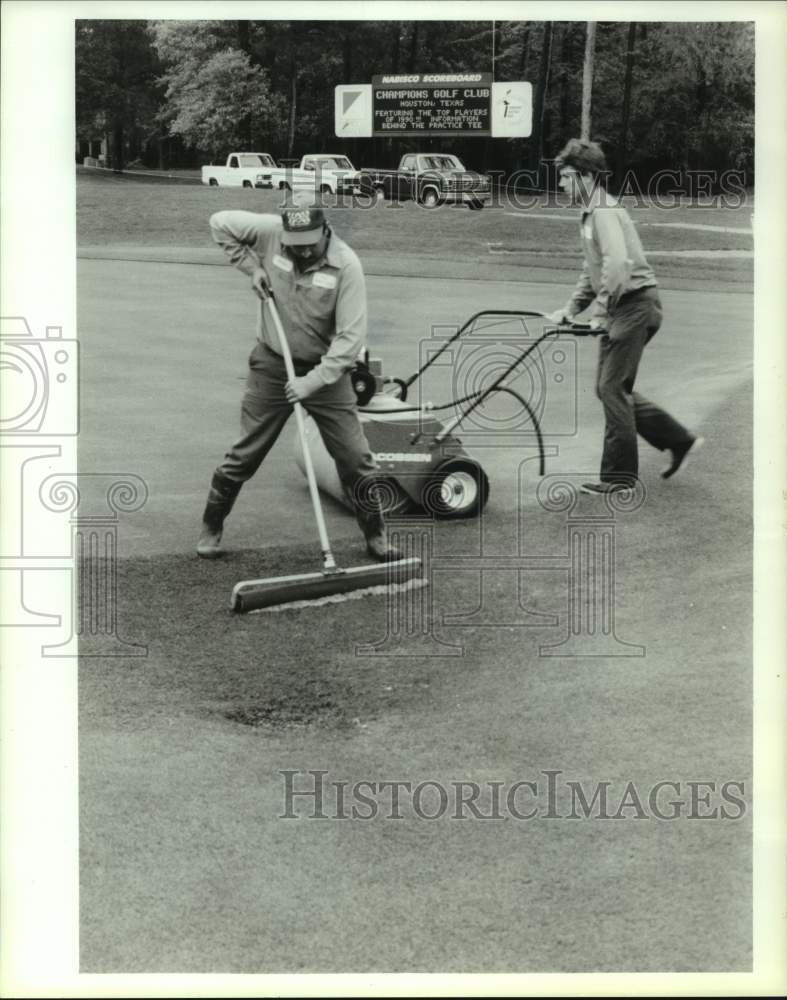 1990 Press Photo Groundskeepers push water from green before play can resume.- Historic Images