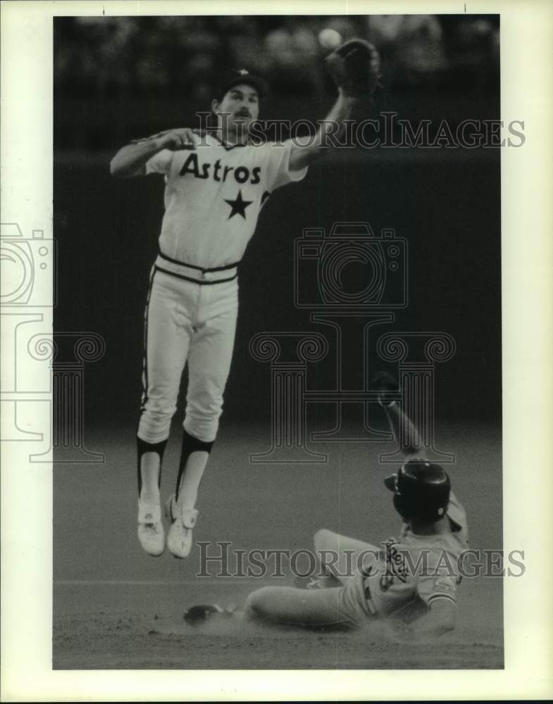 1987 Press Photo Astros&#39; Dickie Thon leaps as Dodgers Mickey Hatcher slides.- Historic Images