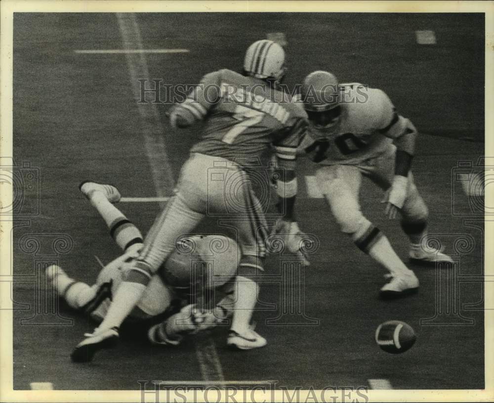 1975 Press Photo Oilers' Pastorini fumbles after being hit by a pair of Bengals.- Historic Images