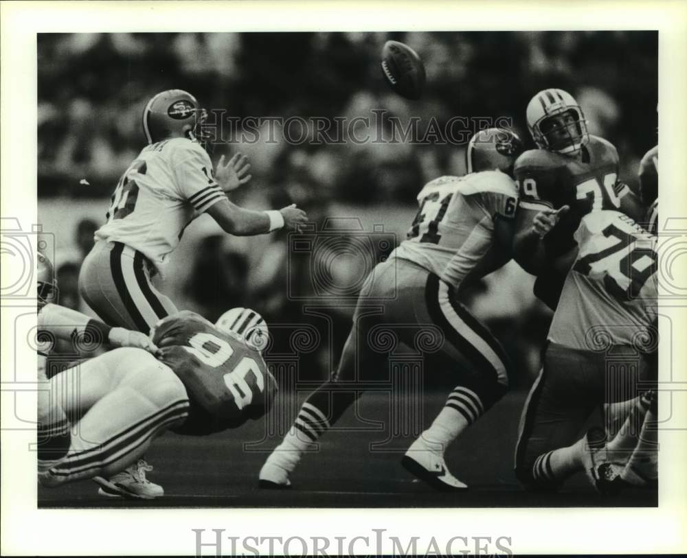 1990 Press Photo 49'ers' Joe Montana fumbles; Oilers' Ray Childress eyes ball.- Historic Images