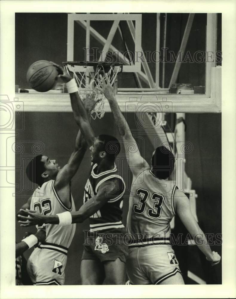 1986 Press Photo Southeastern Louisiana&#39;s T. Butler blocks Rice&#39;s R. Robertson.- Historic Images