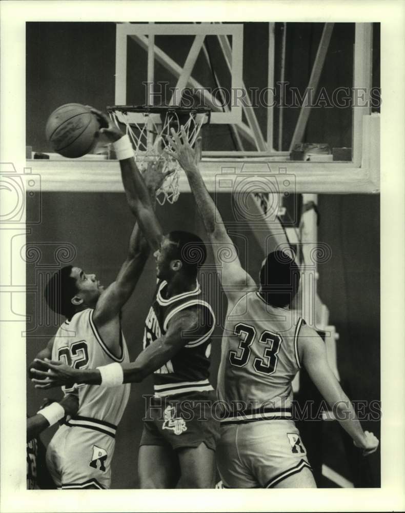 1986 Press Photo Southeastern Louisiana's T. Butler blocks Rice's R. Robertson.- Historic Images
