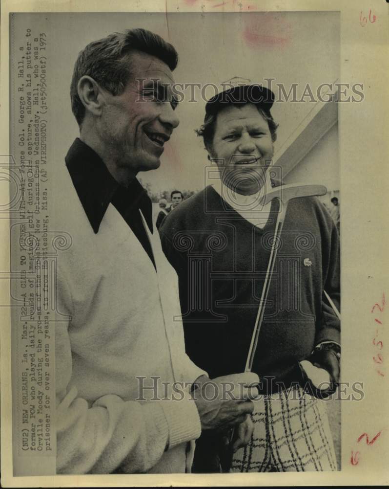 1973 Press Photo Former POW George R. Hall shows Orville Moody his putter.- Historic Images