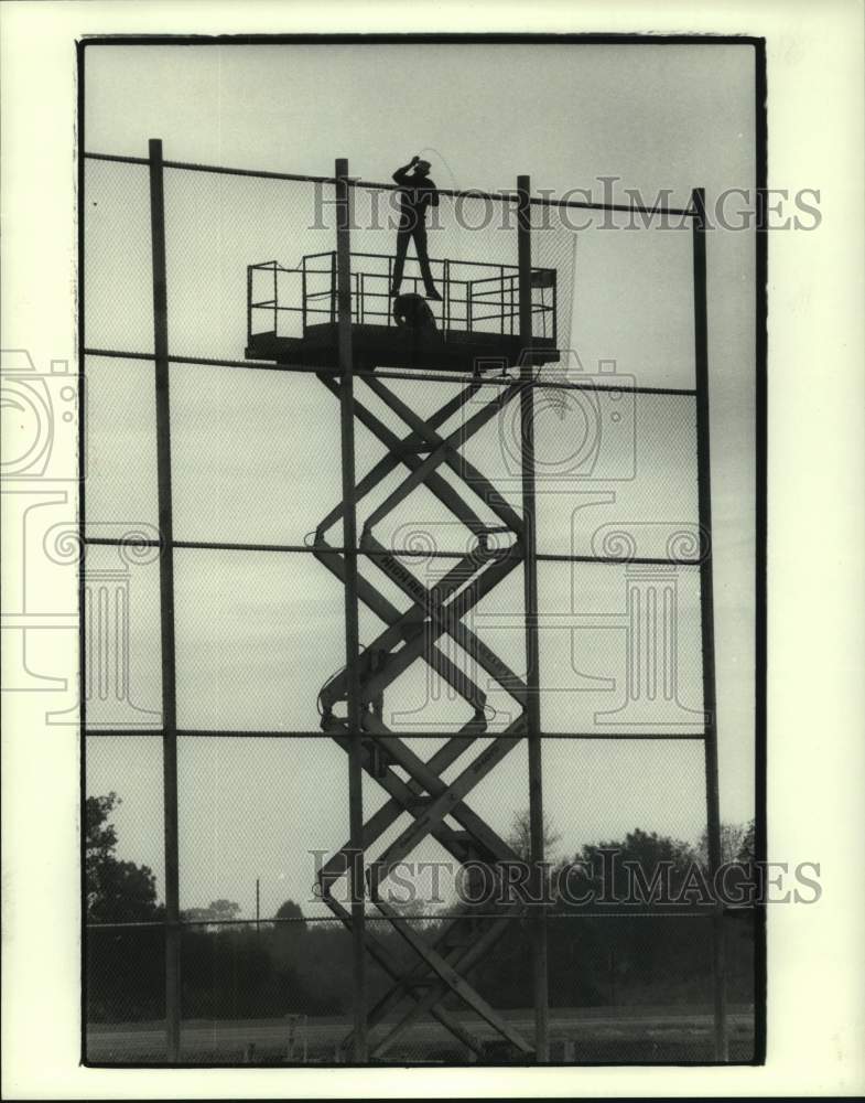 1985 Press Photo Worker on lift hangs wire for fence at Houston Astros camp- Historic Images