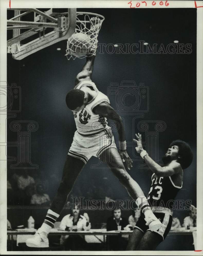 1977 Press Photo Houston&#39;s Mike Schultz hangs from rim after slam dunk.- Historic Images