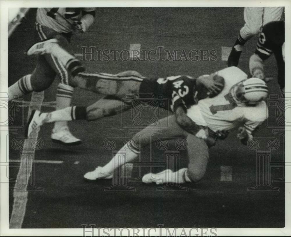 1977 Press Photo Football player Cliff Harris leaps to tackle #7 in a game- Historic Images