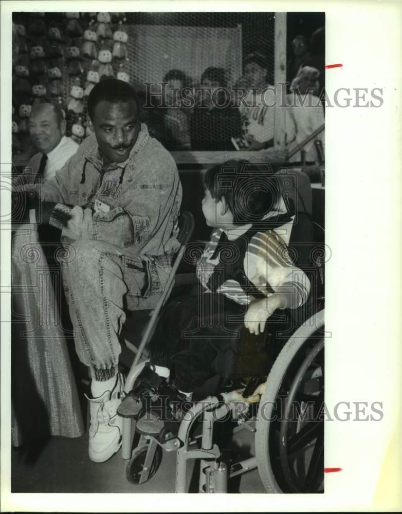 1990 Press Photo Houston Oilers football player Warren Moon with Andrew Arce, TX- Historic Images