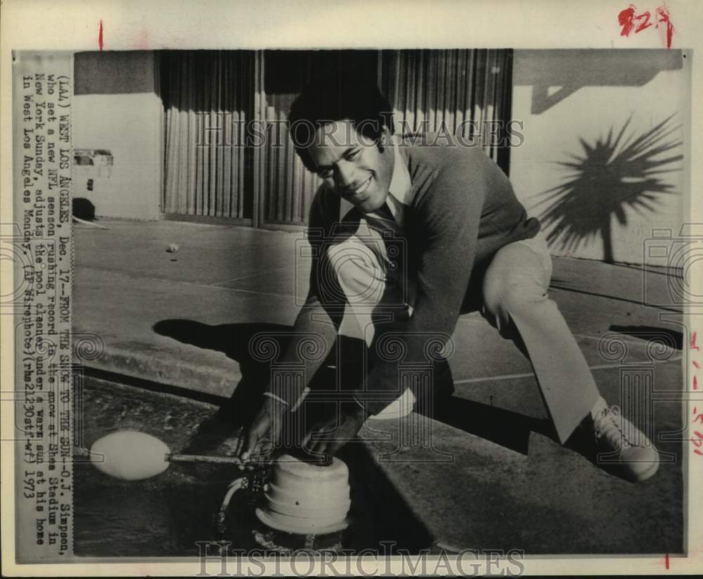 1973 Press Photo Football player O.J. Simpson fixes pool cleaner at his CA home- Historic Images