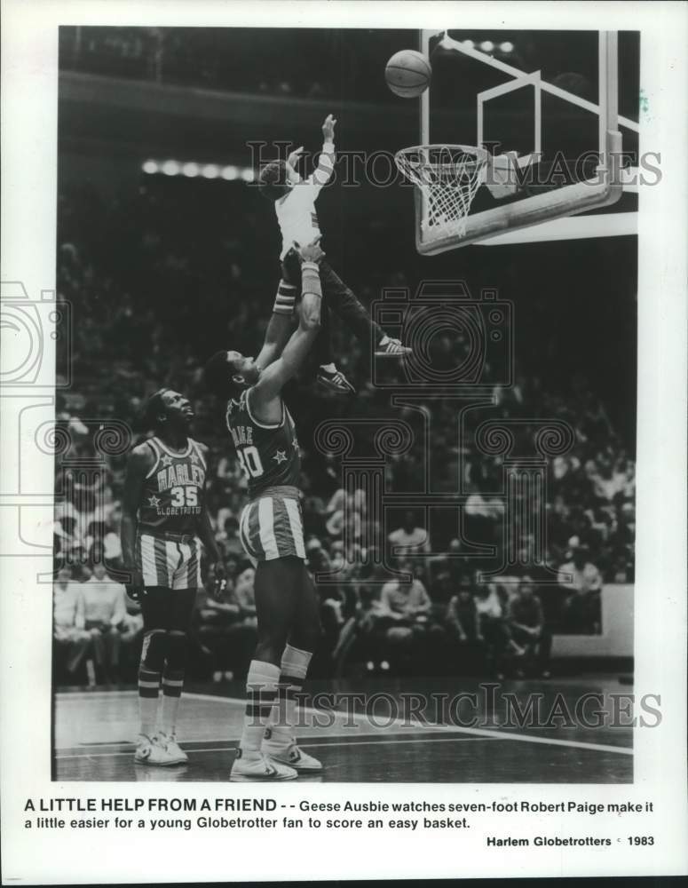 1989 Press Photo Harlem Globetrotters basketball players help child shoot ball- Historic Images