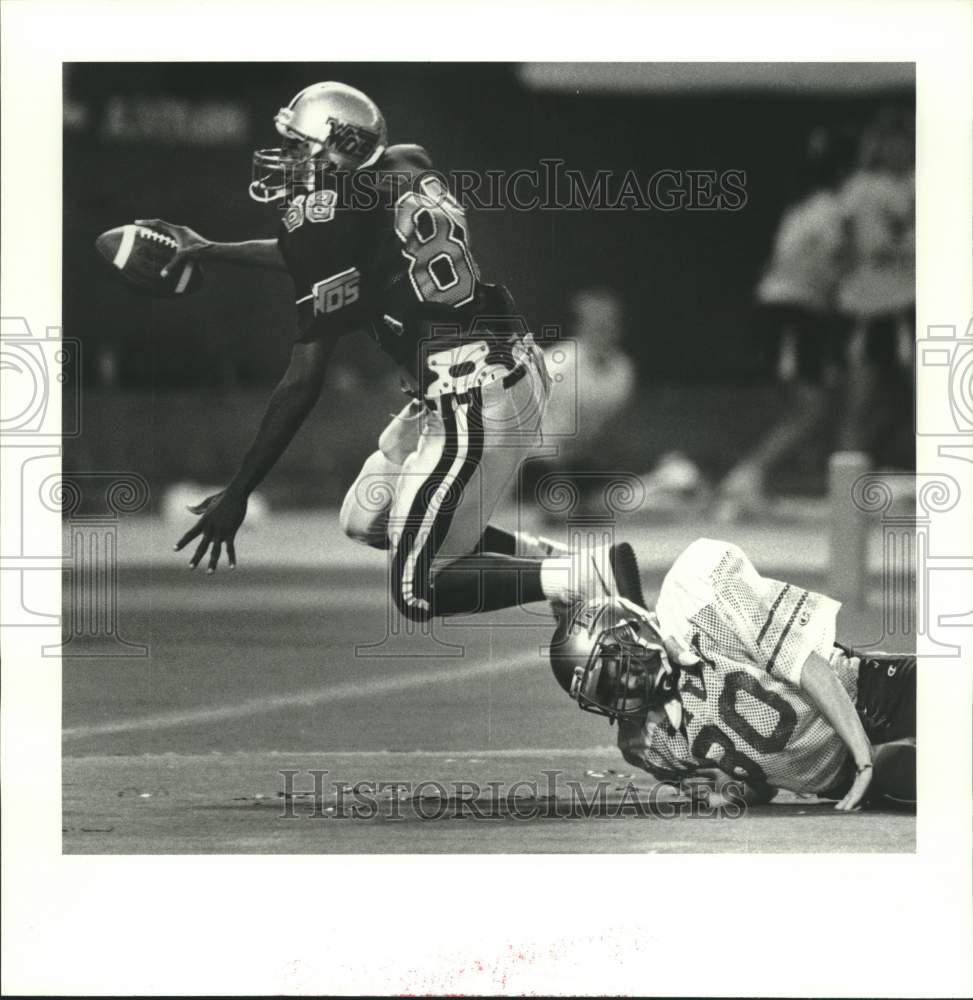 1987 Press Photo West Orange-Stark&#39;s Eric West eludes Tivy&#39;s Matt Scafe for TD- Historic Images