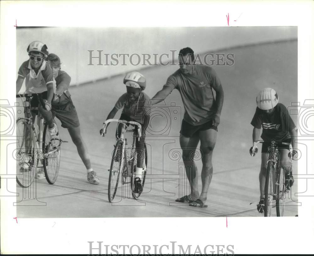 1989 Press Photo Cycling instructor Steve Phillips helps kids at Alkek Velodrome- Historic Images