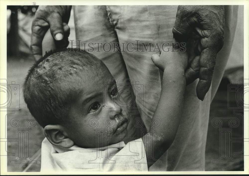 1984 Press Photo A small boy holds the hand of a man at Nicaraguan refugee camp