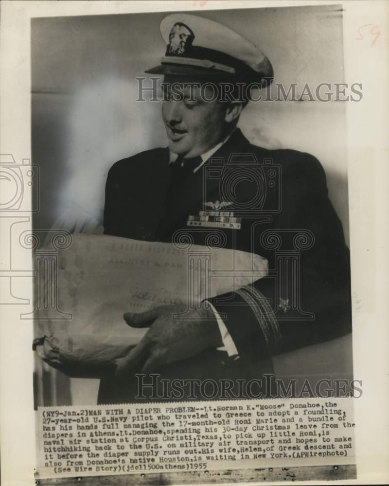 1955 Press Photo Lt. Norman Donahoe juggles foundling and diapers in Greece.