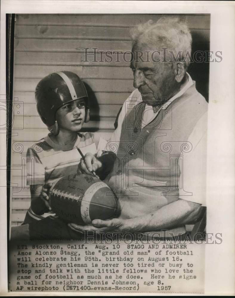 1957 Press Photo Amos Alonzo Stagg autographs football for Dennis Johnson in CA.- Historic Images