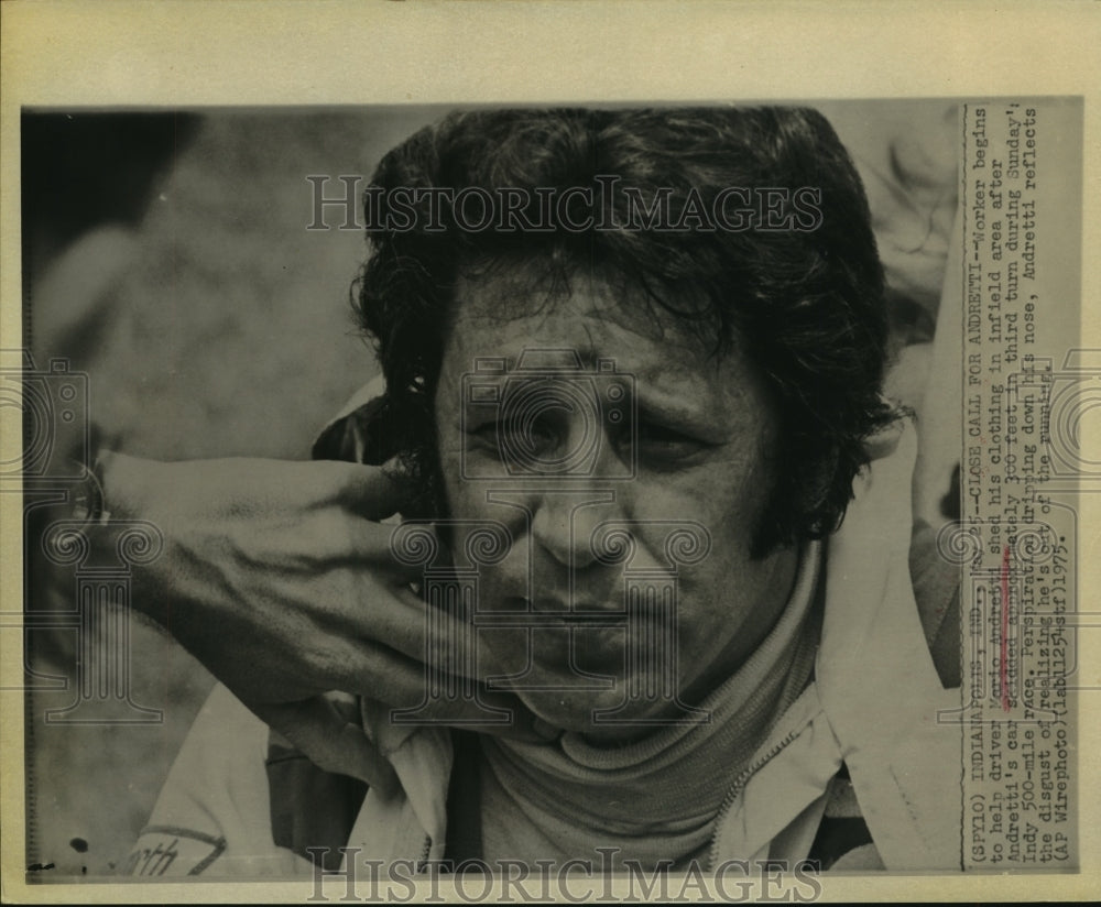 1975 Press Photo Worker helped Mario Andretti shed clothing at Indy 500 race