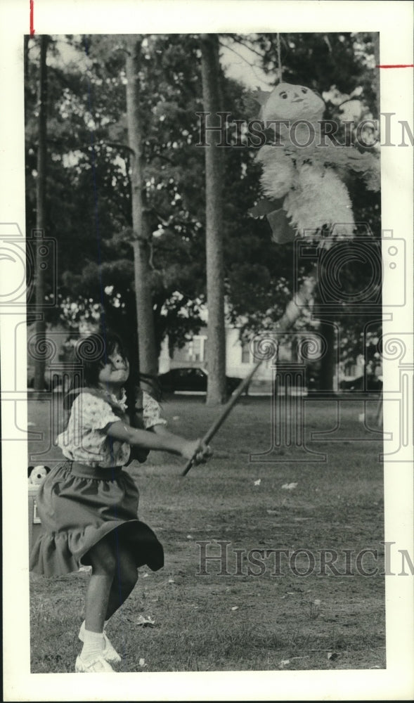 1978 Press Photo Linda Castillo breaks a pinata in Woodland Park, Houston- Historic Images