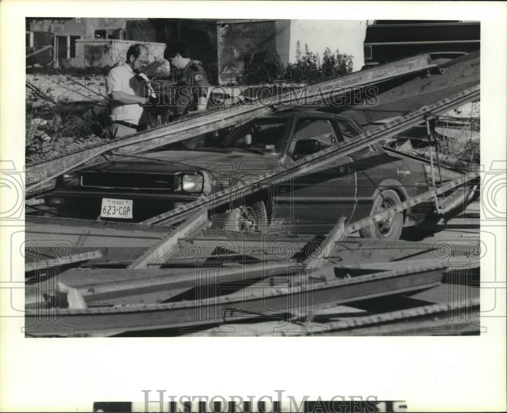 1986 Press Photo Seabrook officer Rick Fuller and Paul Smith inspect car wreck- Historic Images