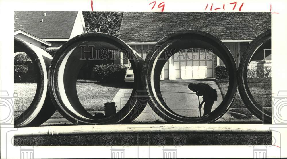 1983 Press Photo Charles McHenry clears dirt from storm sewer pipes in Houston
