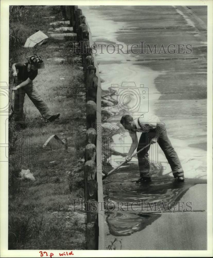 1990 Press Photo Houston firefighters clean dye off Interstate 10 in Houston