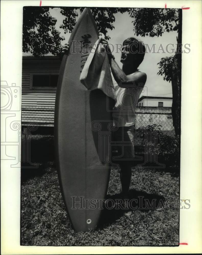 1988 Press Photo Surfer Bobby Morrow cleans his board - hcx21775- Historic Images