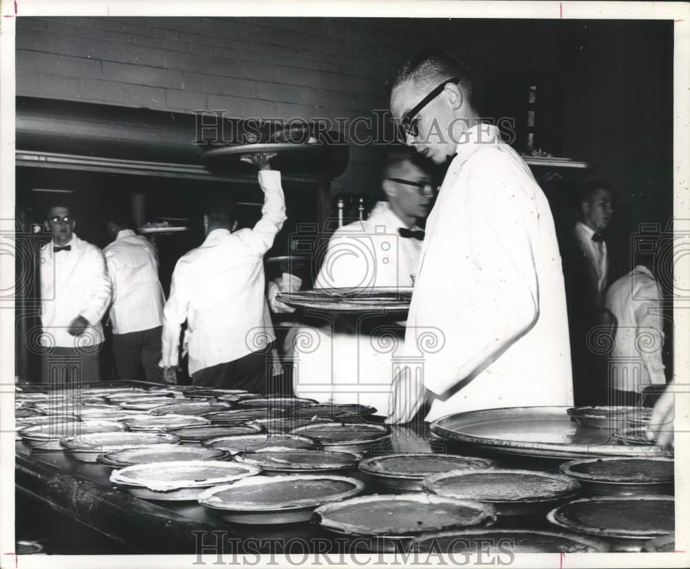 1961 Press Photo Student waiters pick up pies from kitchen during formal event