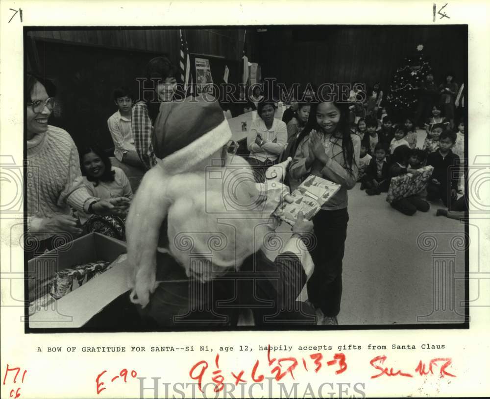 1983 Press Photo Si Ni receives a Christmas gift from Santa Claus in Houston