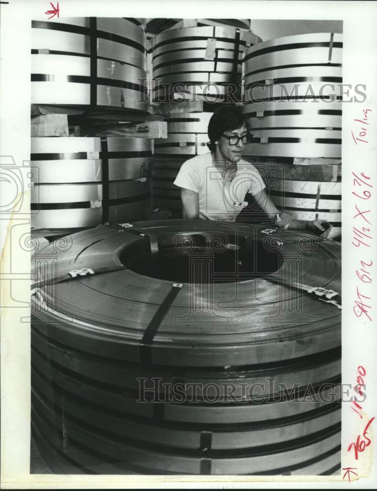 1983 Press Photo Employee checks sheet metal coils in Tenneco plant in Virginia- Historic Images
